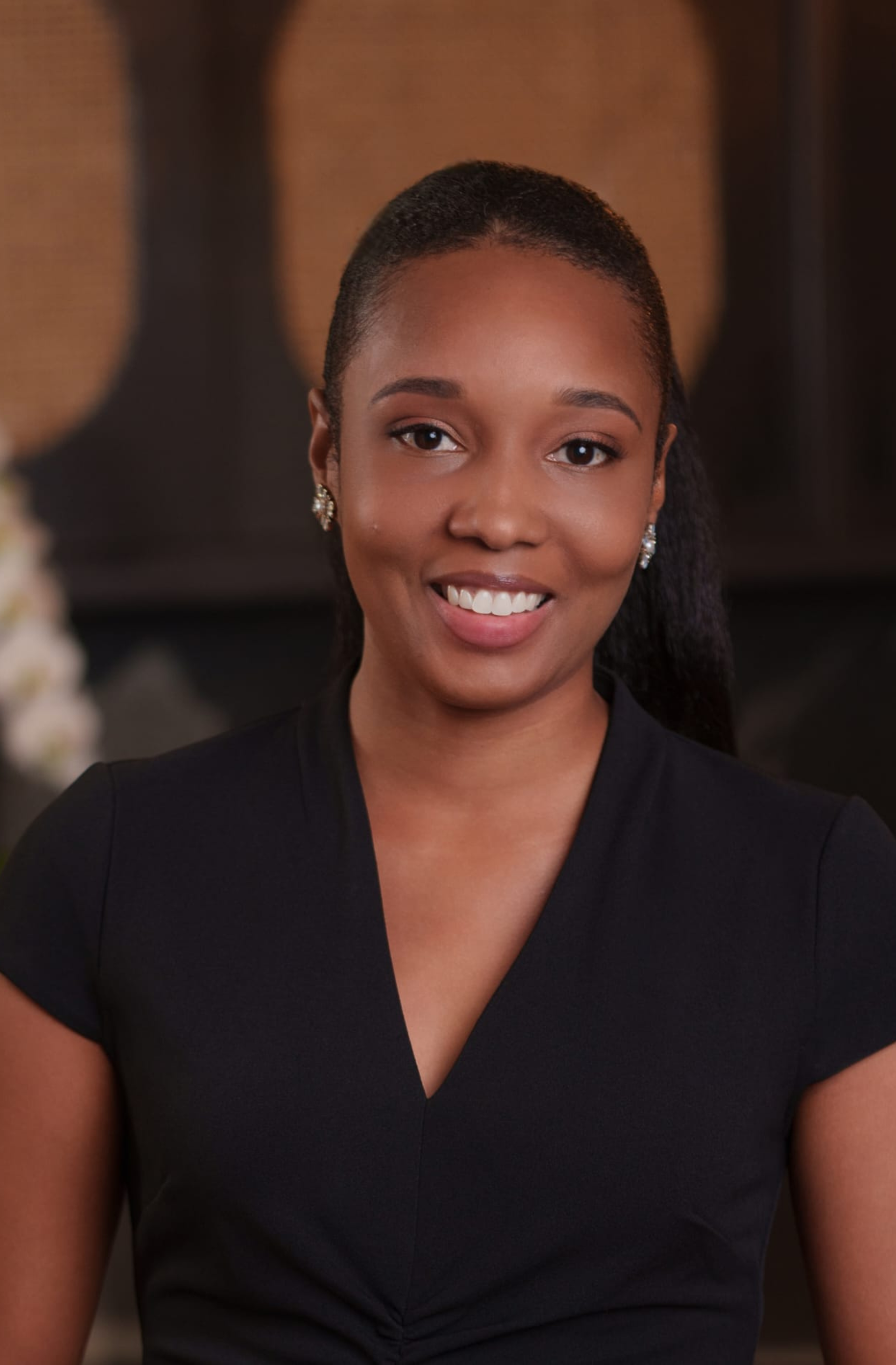 A woman is sitting at a with a white orchid behind her