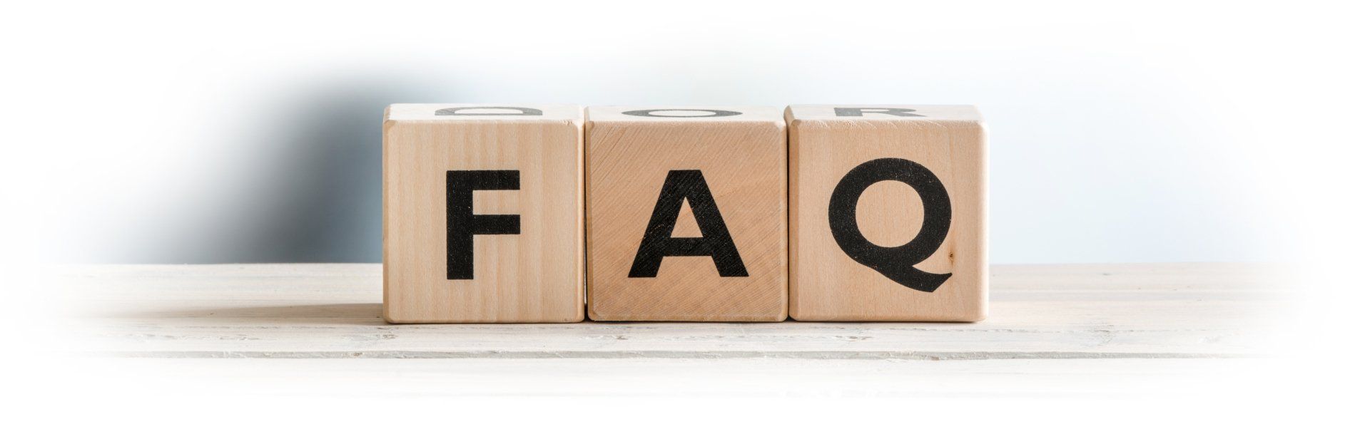 Three wooden blocks that spell FAQ (Frequently Asked Questions)