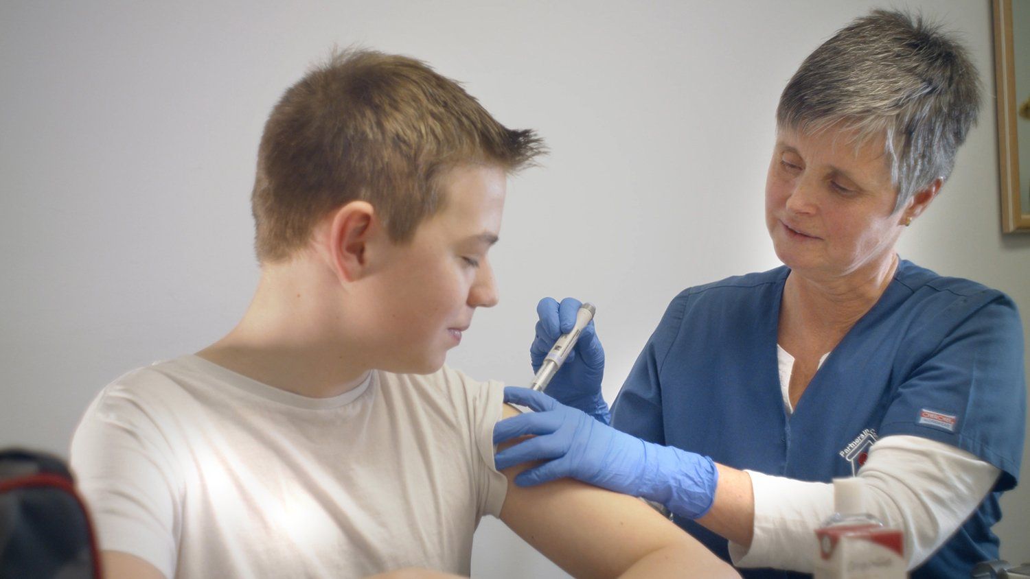 Boy in school receiving IV treatment from nurse