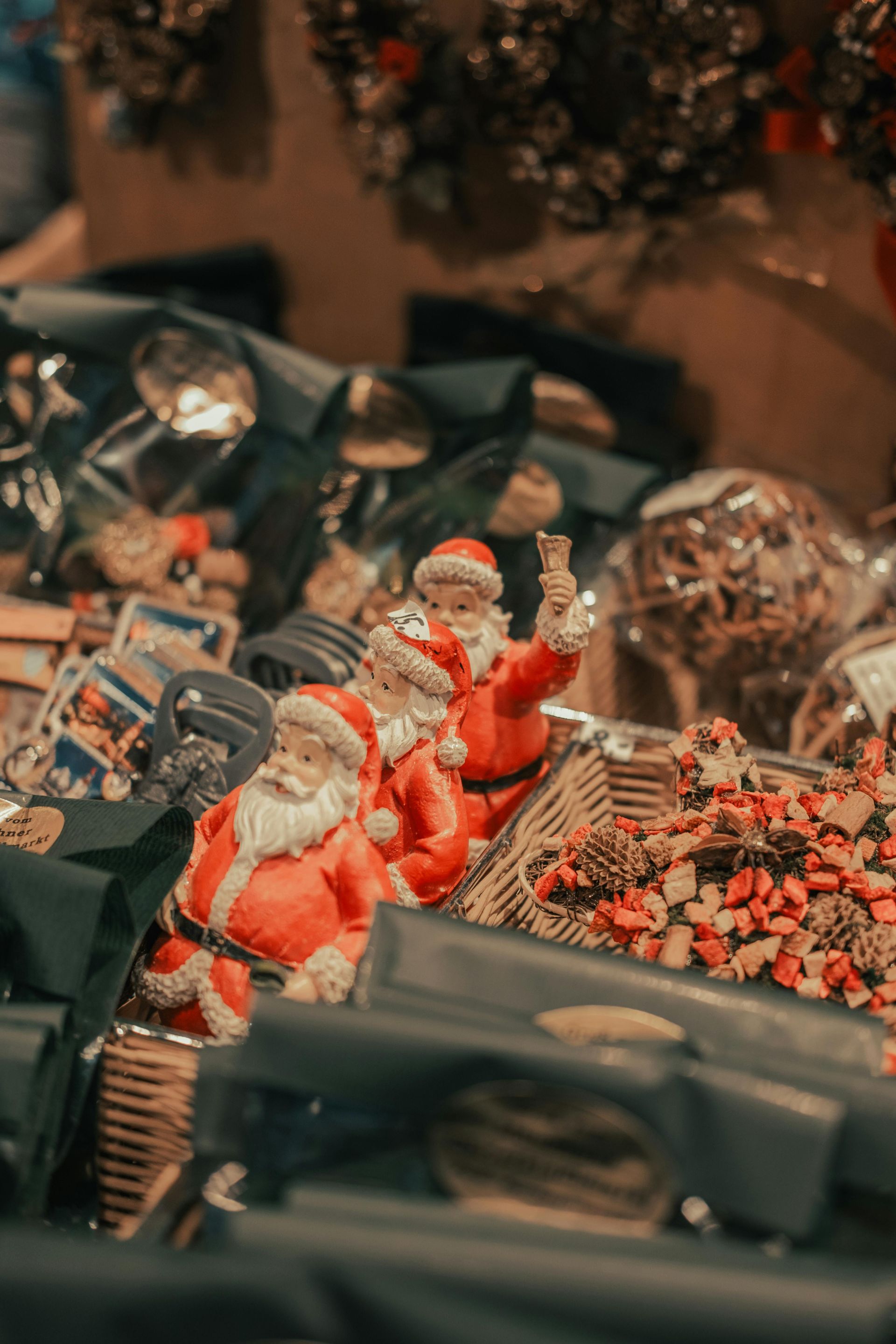 A display of several small Santa Claus figurines dressed in red and white, surrounded by holiday decorations.