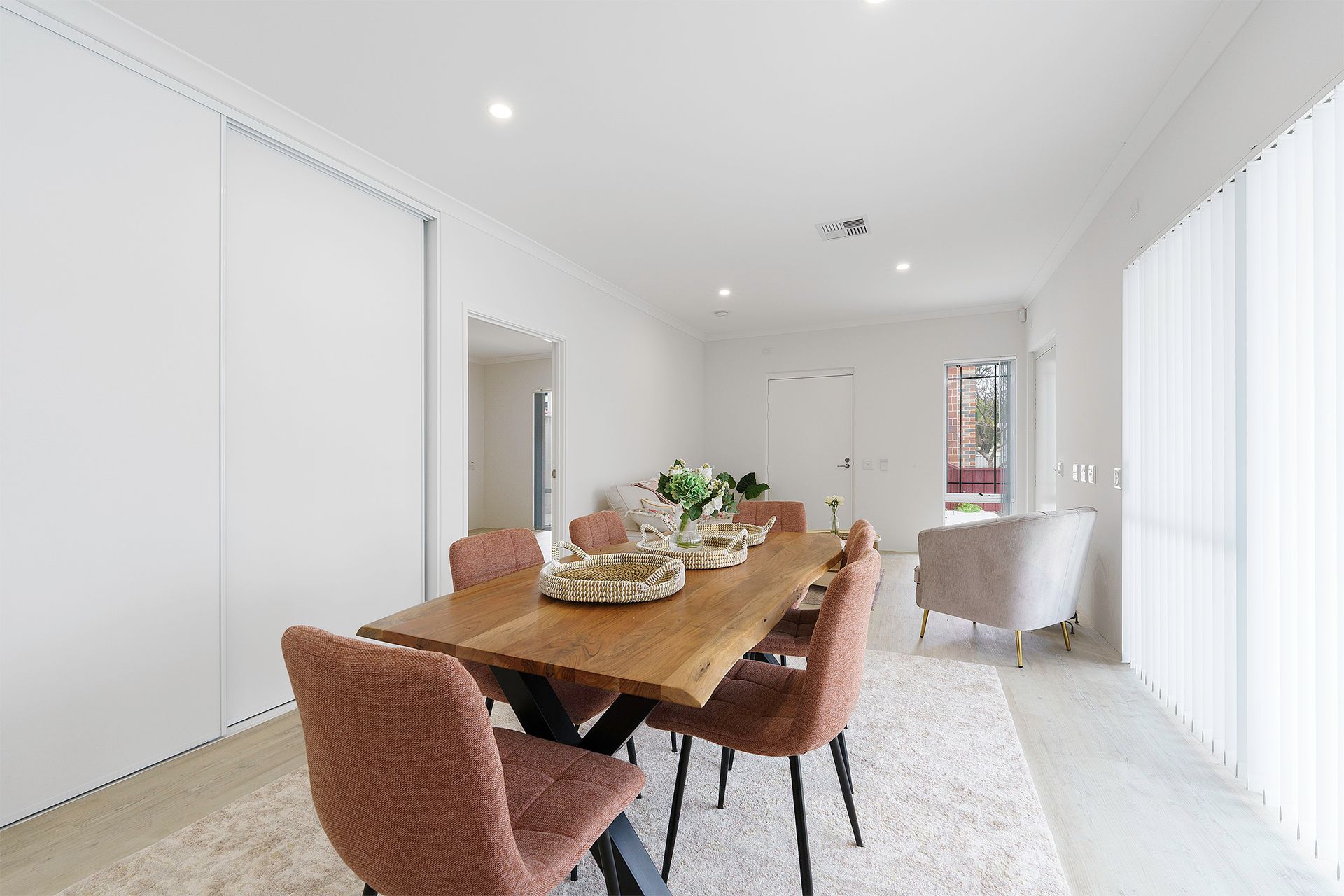 Ilios Living accommodation for people with disabilities – Carlie location dining room with a wooden table and pink chairs.