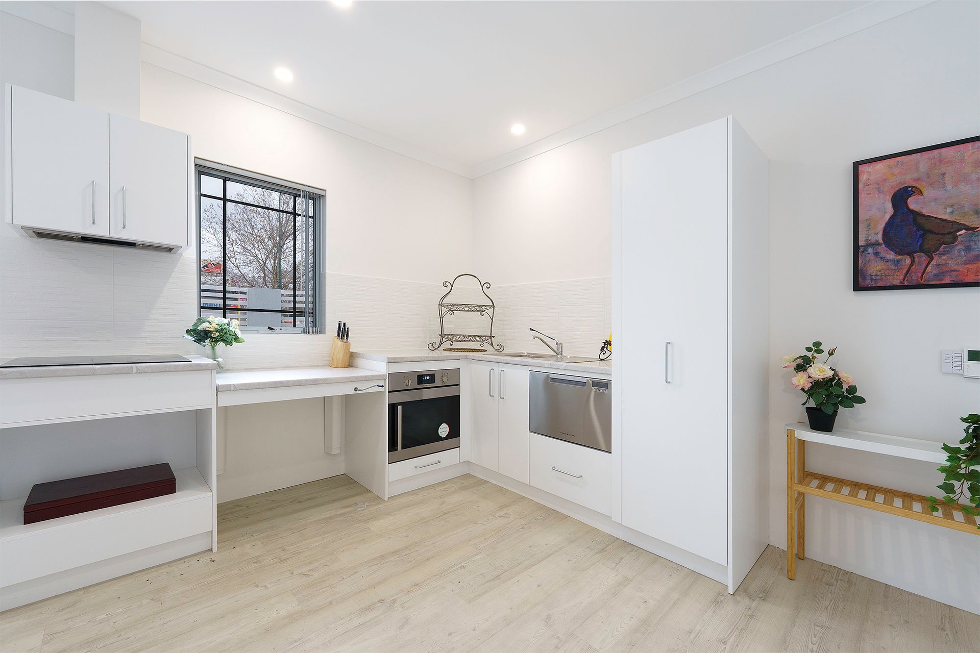 Ilios Living Disability Accommodation Carlie location kitchen with white cabinets, stainless steel appliances, a sink and a window