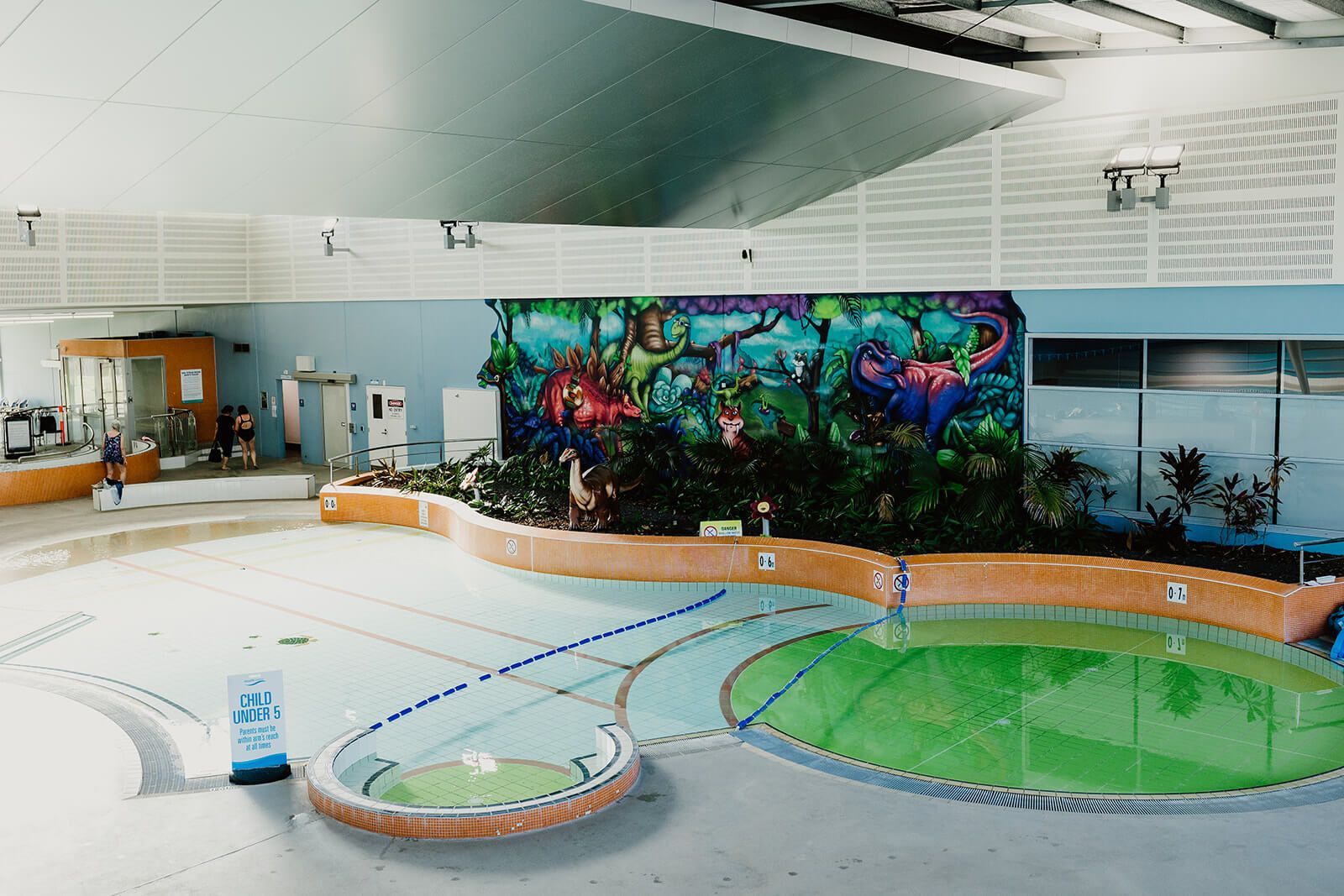 Ilios Living accommodation for people with disabilities – A large indoor swimming pool with a mural on the wall near our Carlisle location.