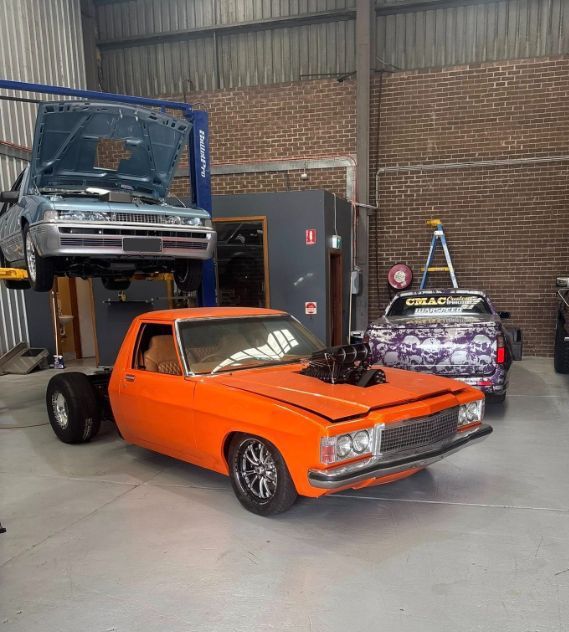 Orange Custom Hot Rod in A Garage with Other Vehicles — Level Up Automotive In Unanderra, NSW