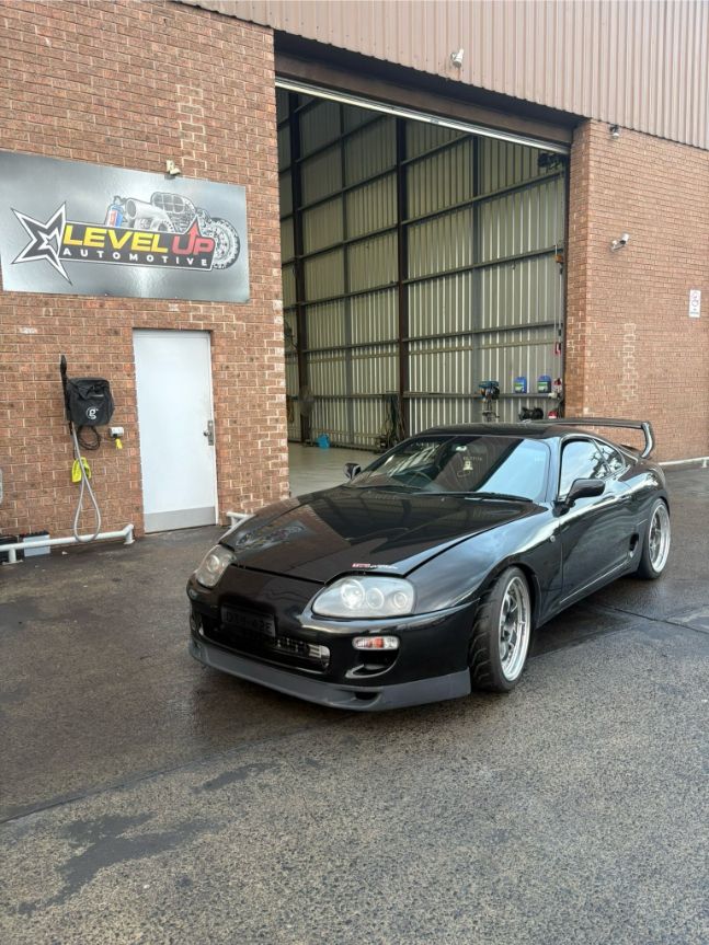 Black Toyota Supra Sports Car in Front of A Garage — Level Up Automotive In Unanderra, NSW