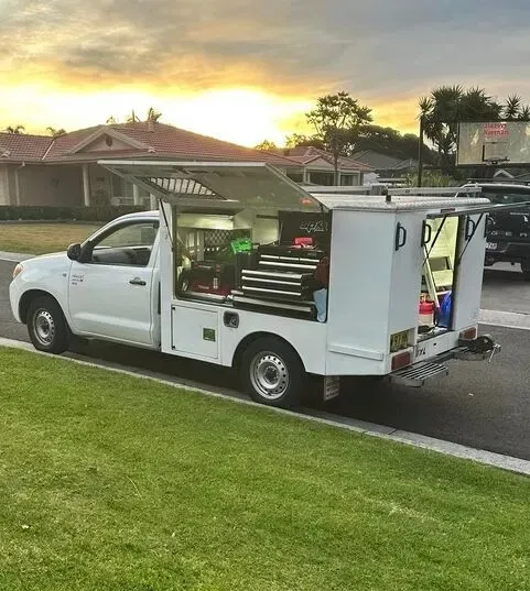 White Utility Truck with Open Compartments Parked on Grass  — Level Up Automotive In Unanderra, NSW