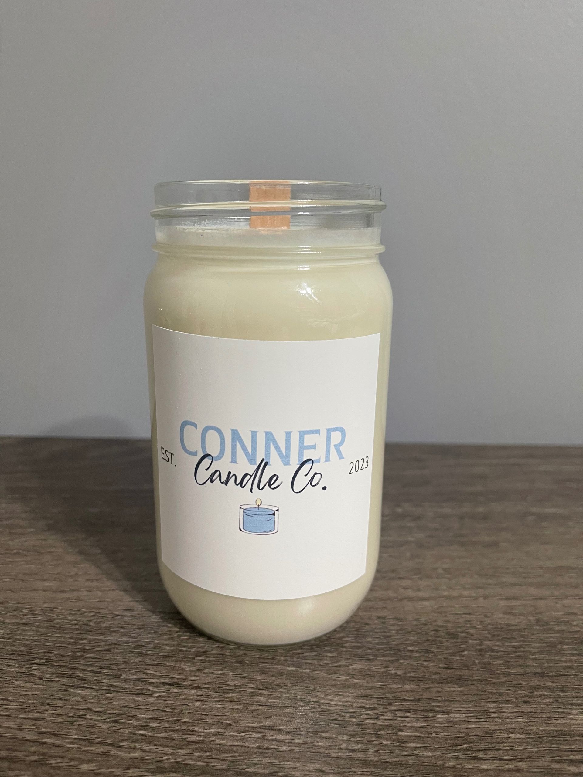 Mason jar candle with white wax, label reads 