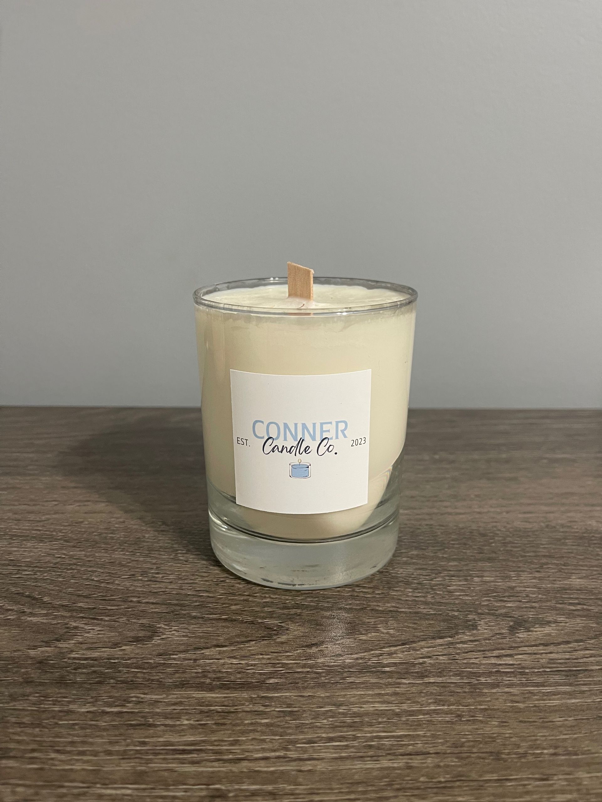 Candle in a clear glass with a wooden wick, labeled 