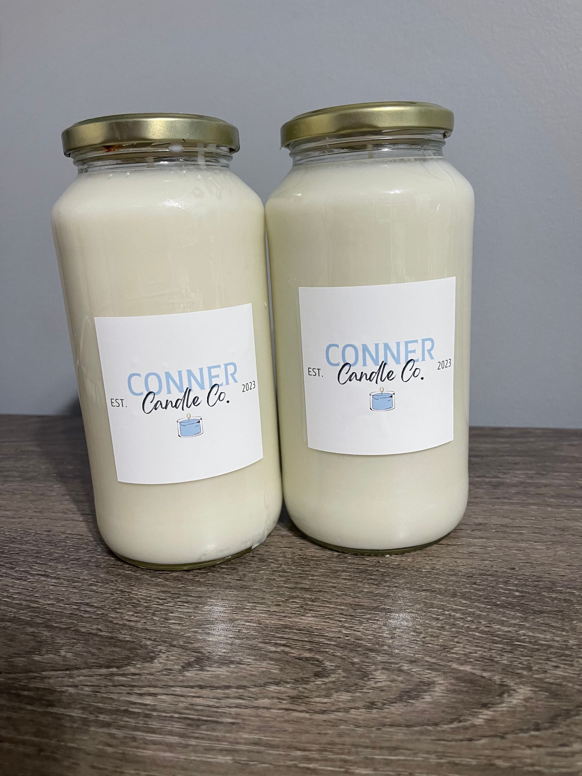 Two glass jars filled with a creamy, white liquid, labeled 