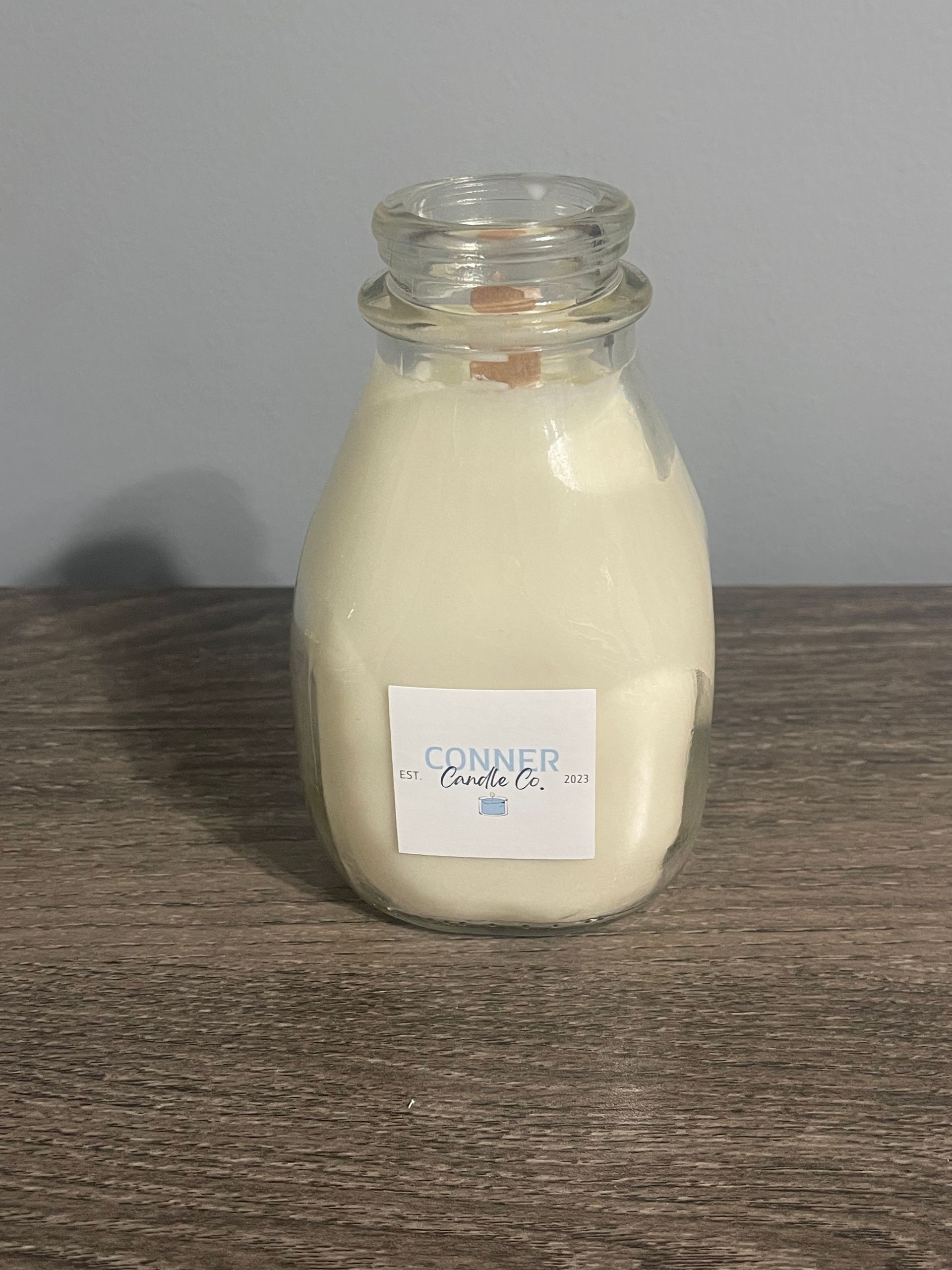 Glass milk bottle filled with white powder, label reads 