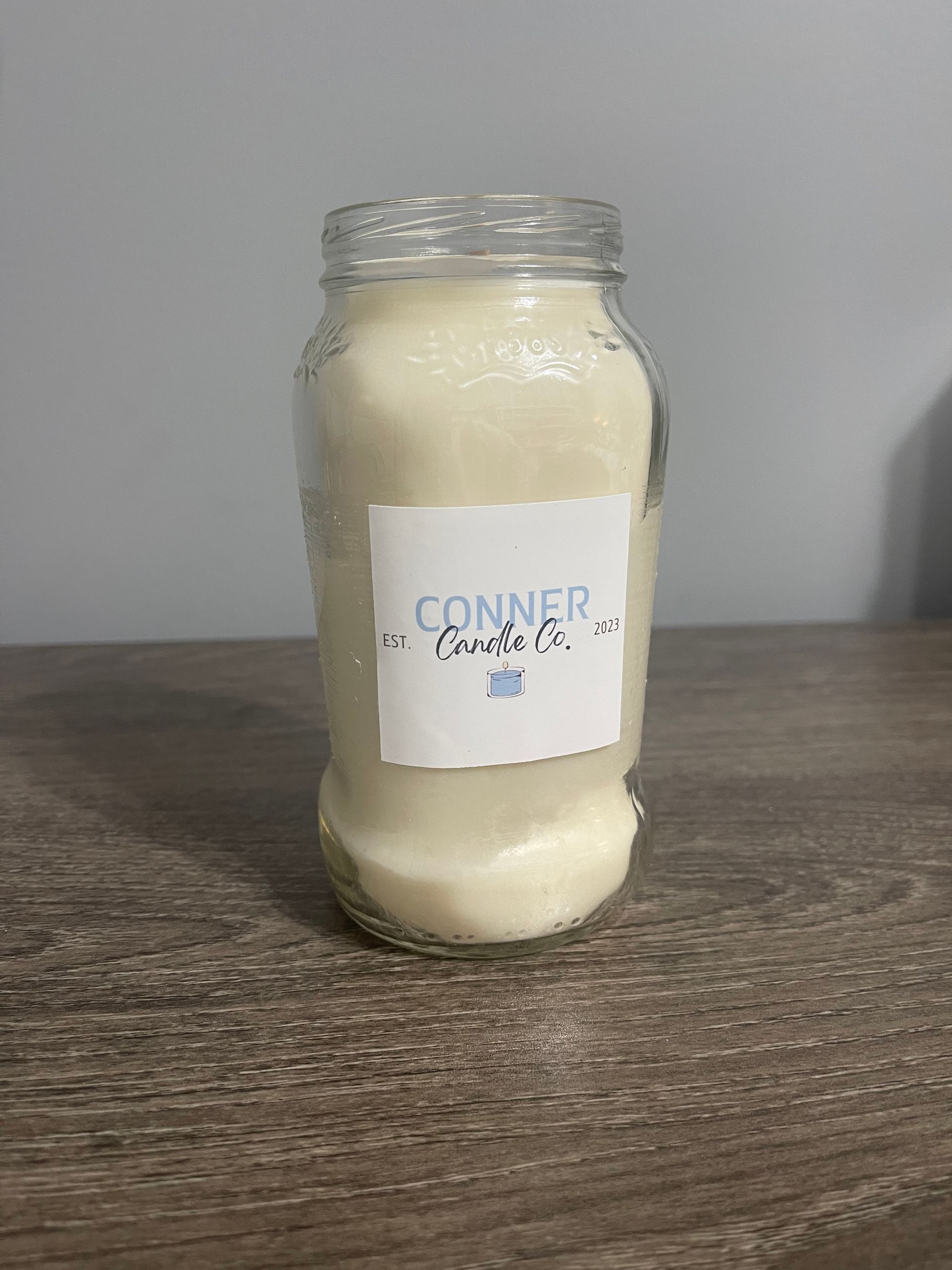A jar filled with white powder on a wooden surface with a label that says 
