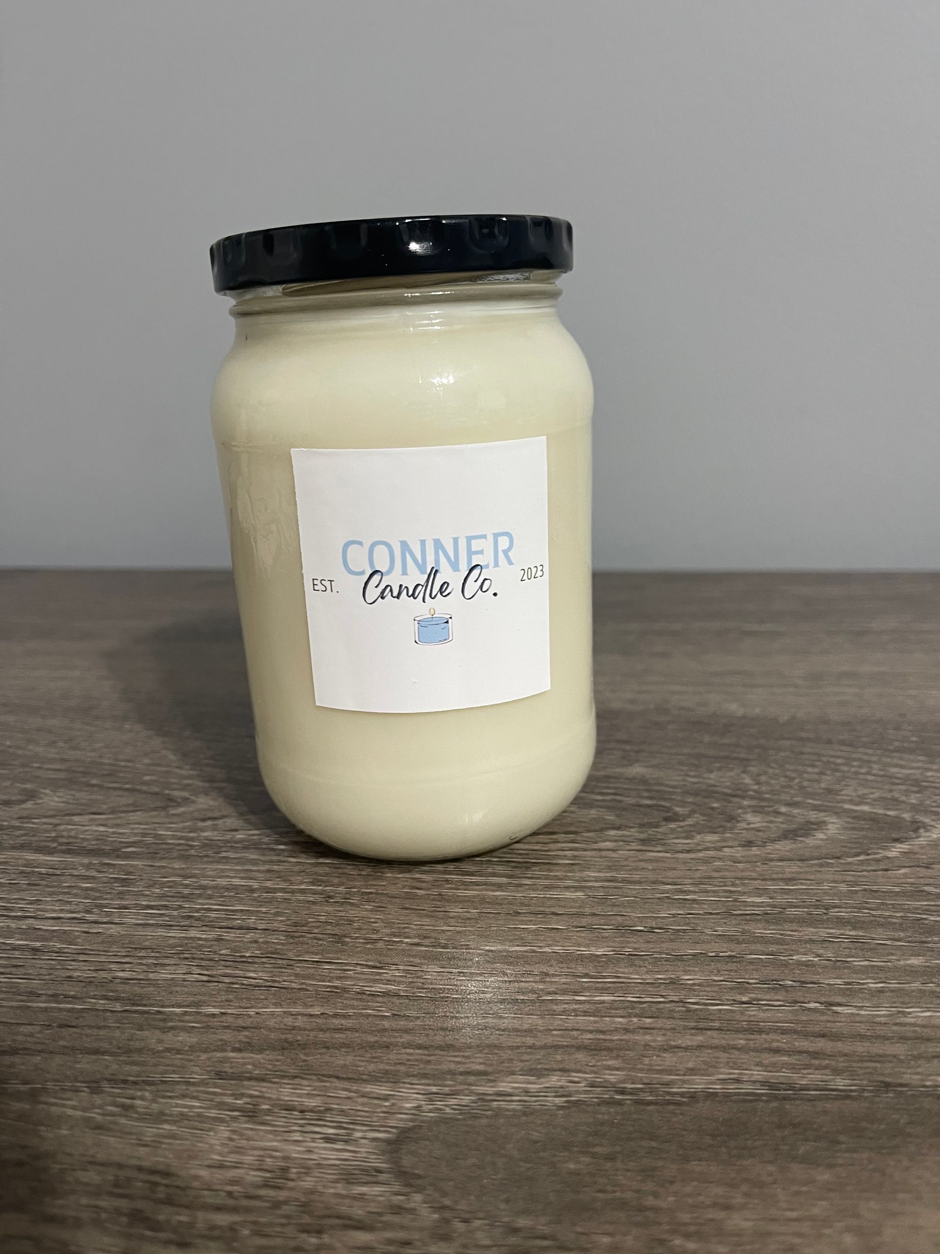 Jar of off-white cream with a black lid and a label that reads 