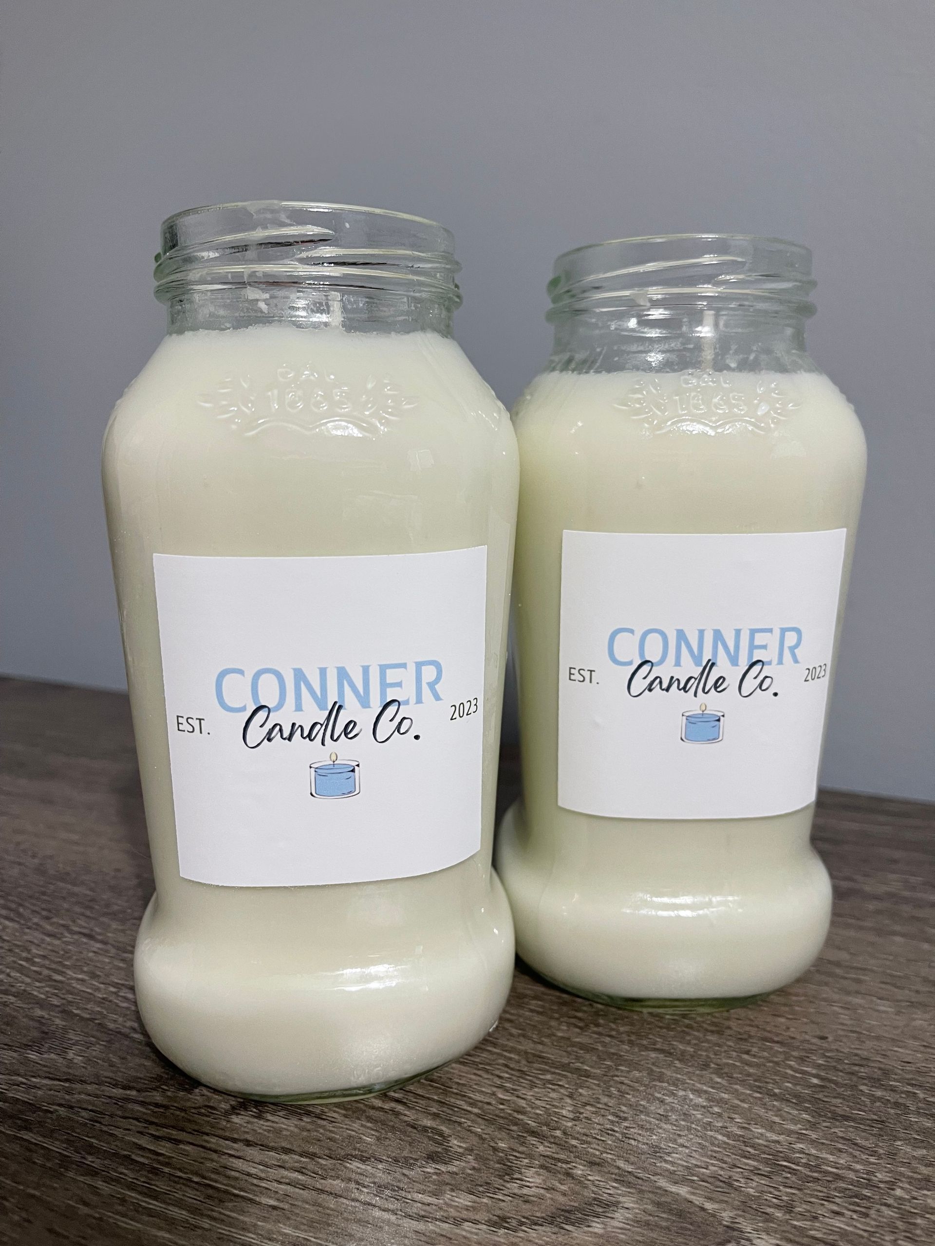 Two white candle jars with 