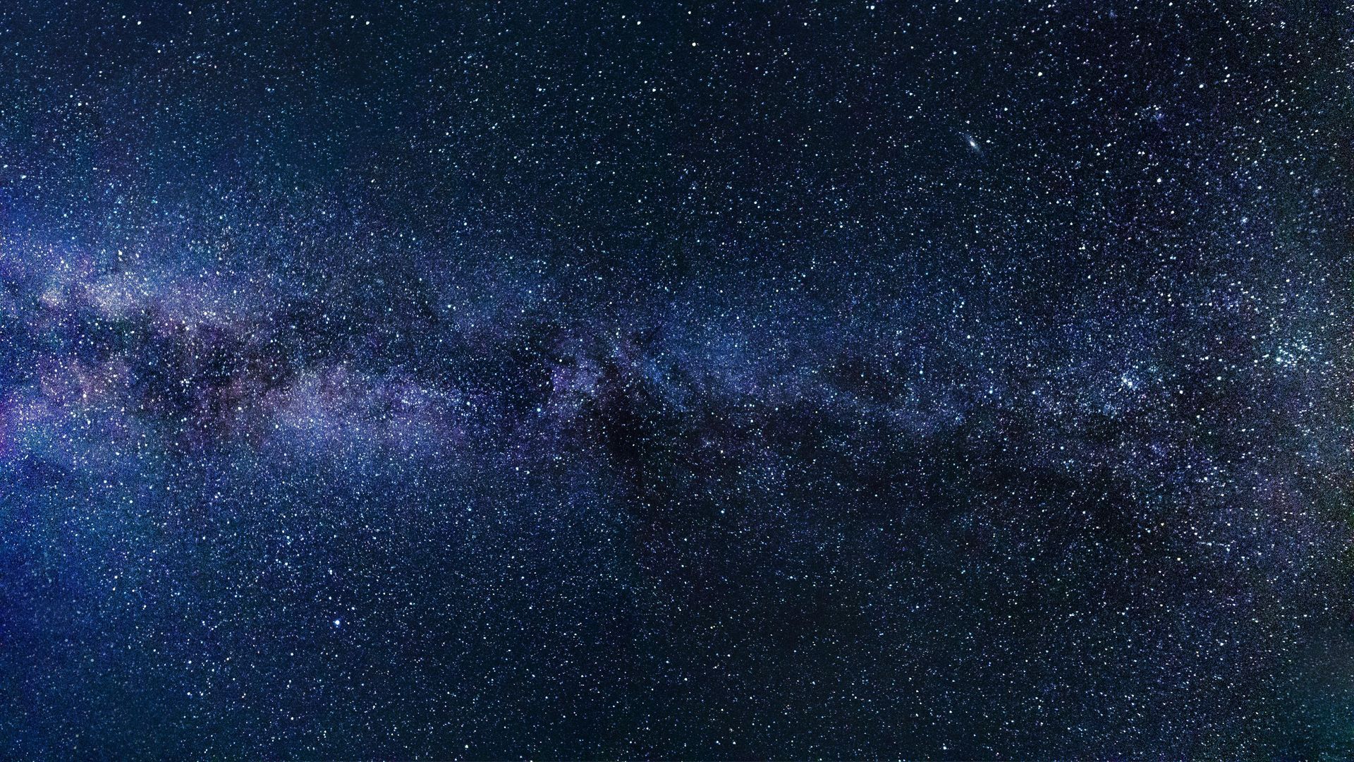 Night sky filled with countless stars, vibrant purples and blues of the Milky Way.