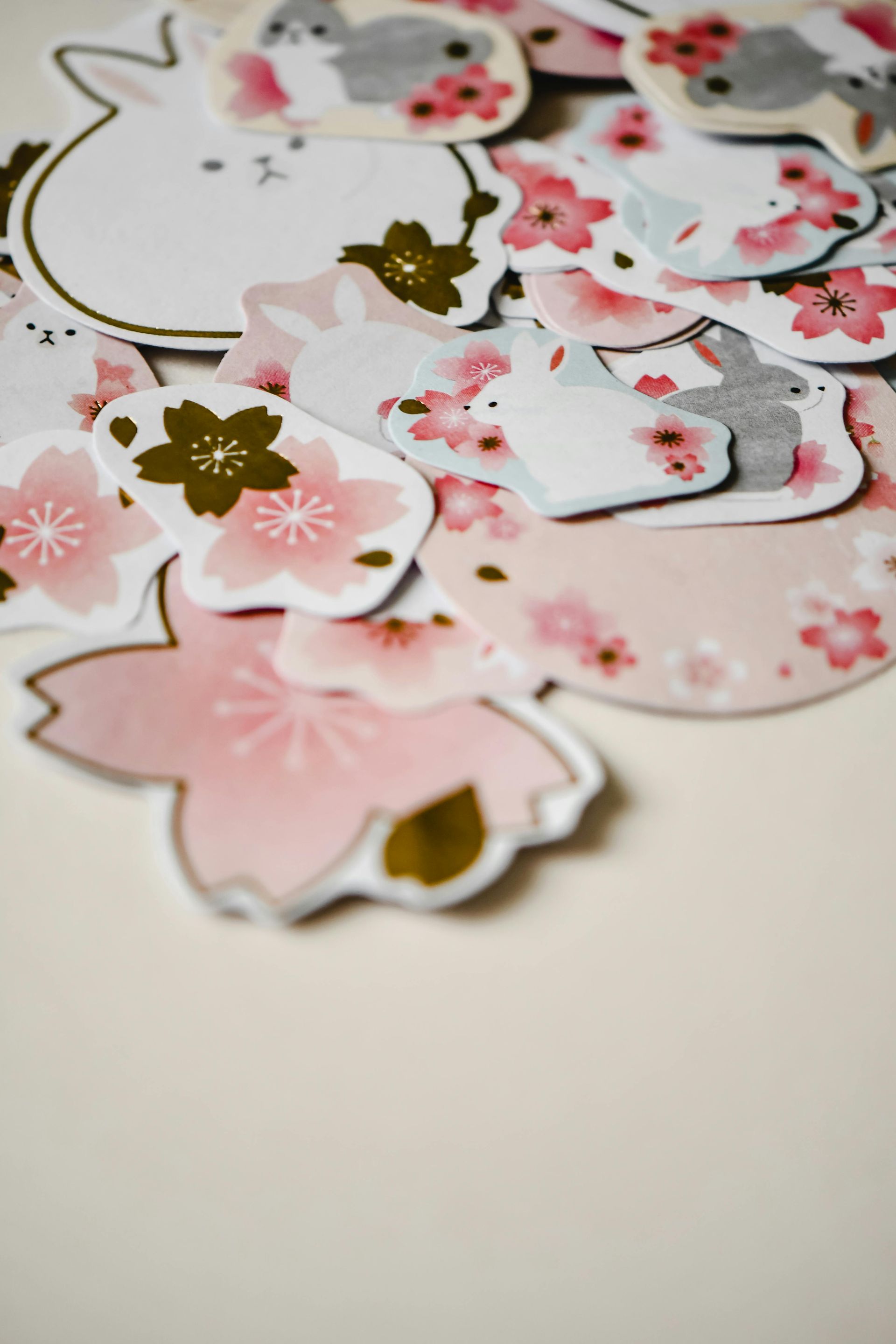 Pile of pink flower and bunny-shaped paper cutouts with gold and white accents.