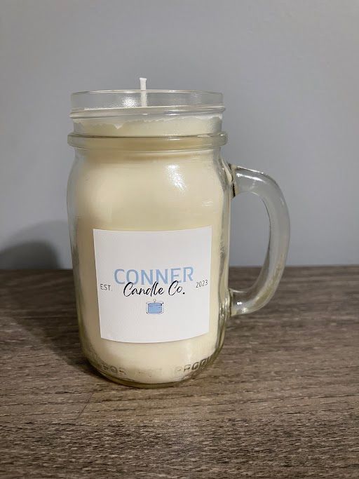 Candle in a mason jar with a handle, labeled 