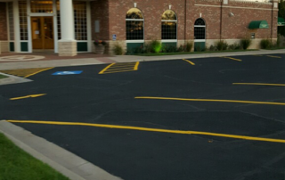 A brick building with a parking lot in front of it