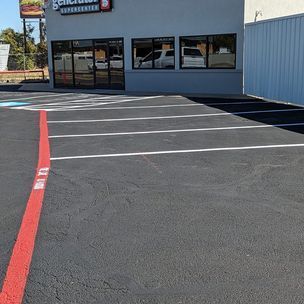 A parking lot with a red line in front of a building.