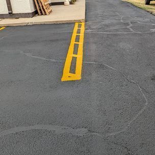 A yellow line is painted on the side of a parking lot.