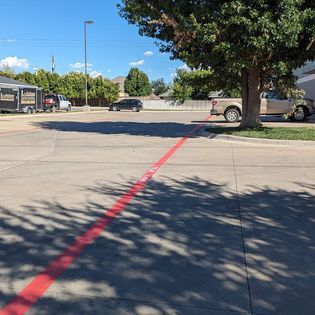 A red line is painted on the side of a parking lot.
