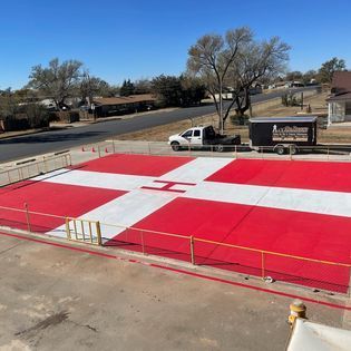 A red and white cross with the letter h painted on it