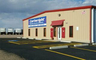A cartwright building with a parking lot in front of it