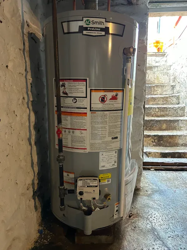 A smith water heater is sitting in a basement next to stairs