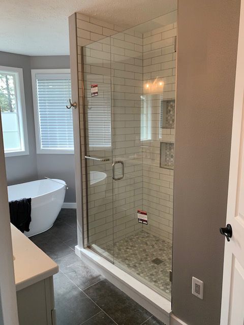 A bathroom with a tub and a walk in shower