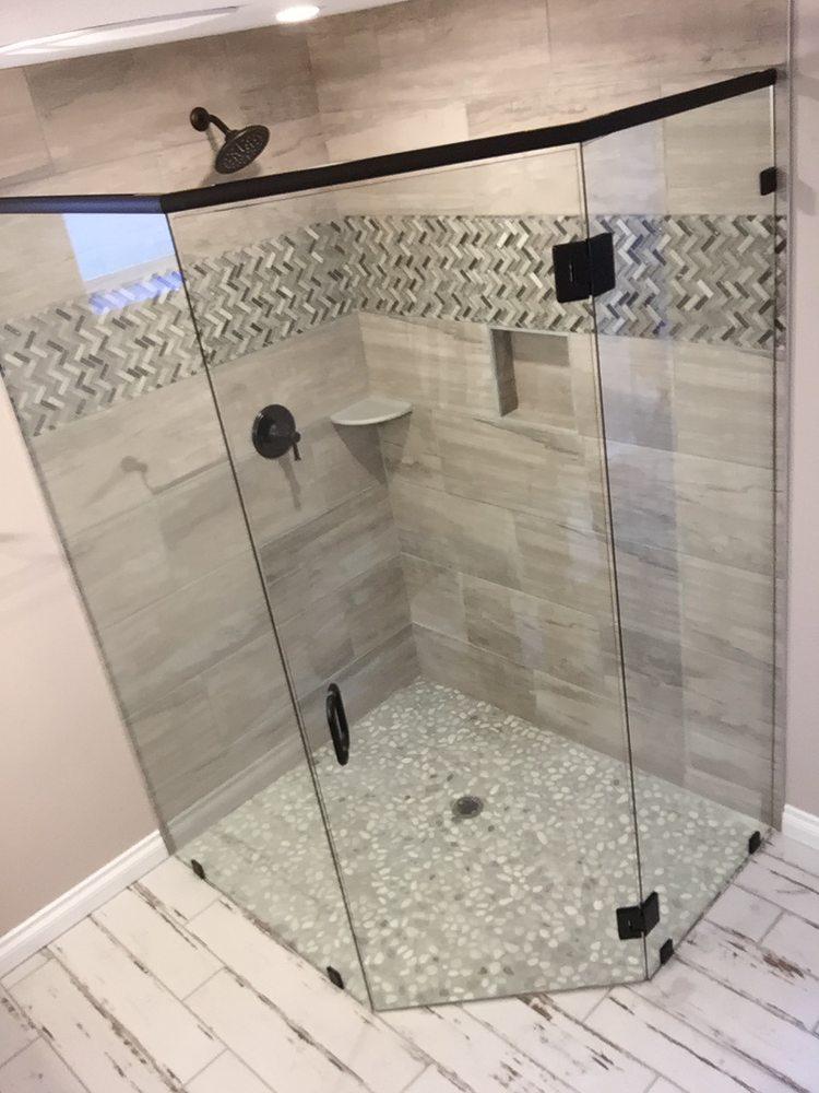 A shower stall with a glass door and a shower head in a bathroom.