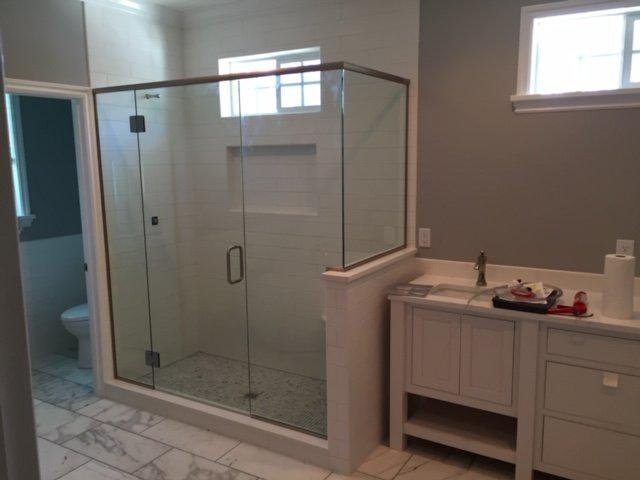 A bathroom with a walk in shower and a sink