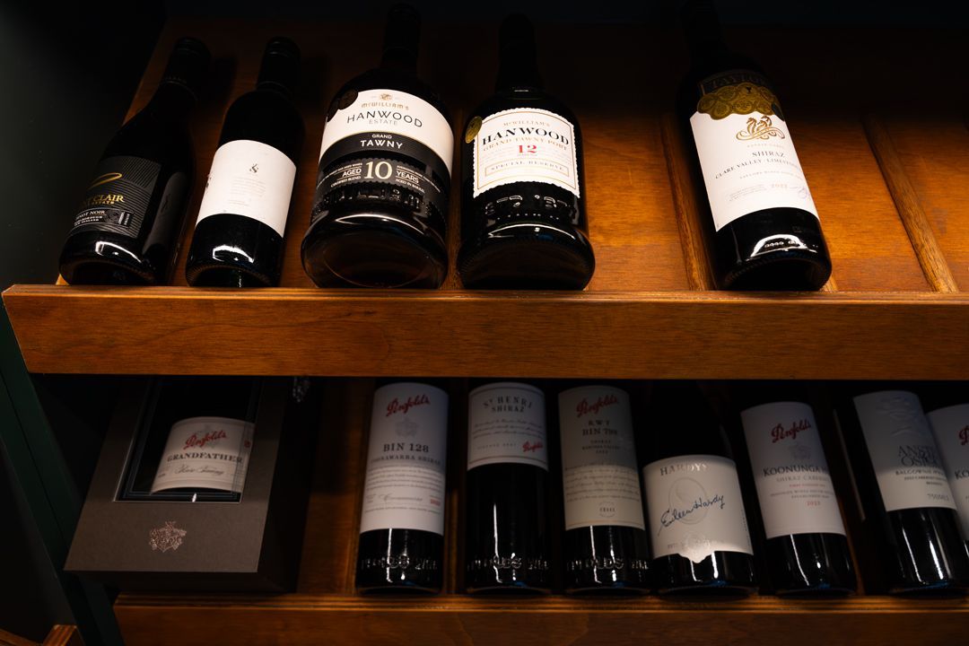 Wine bottles on wooden shelves.