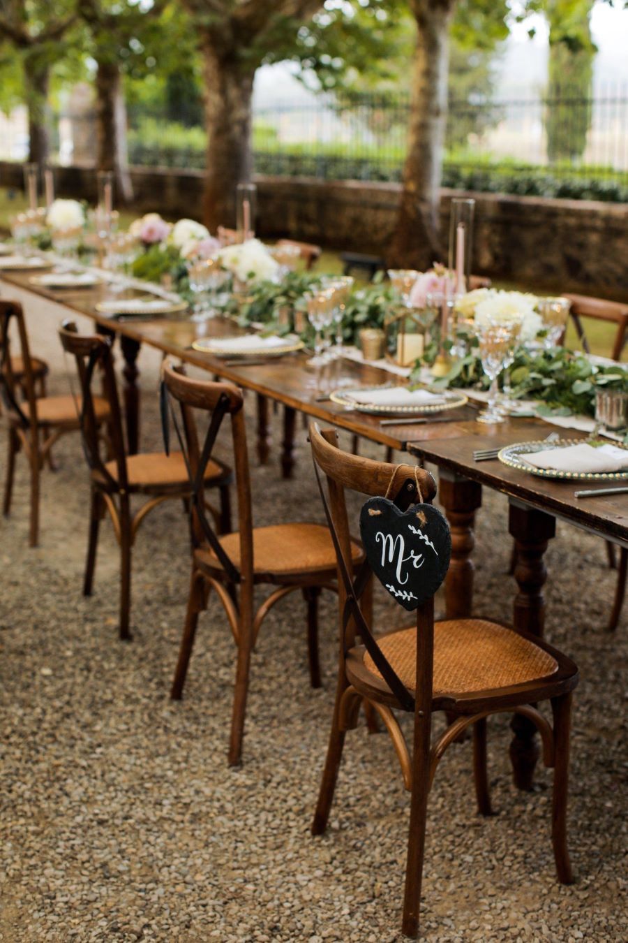 A Long Table With Chairs and Plates Set for a Wedding Reception — Custombuilt Furnishers in Svensson Heights, QLD