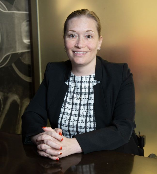 A group of people are sitting around a table having a meeting.