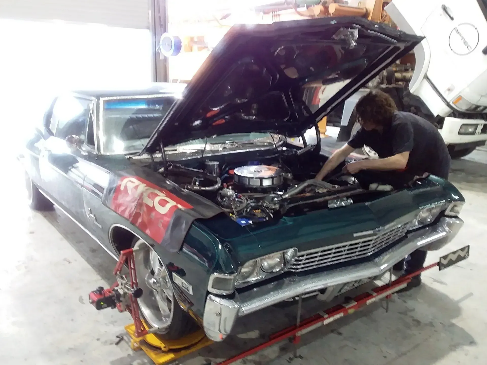 A red and white truck is parked in a garage.