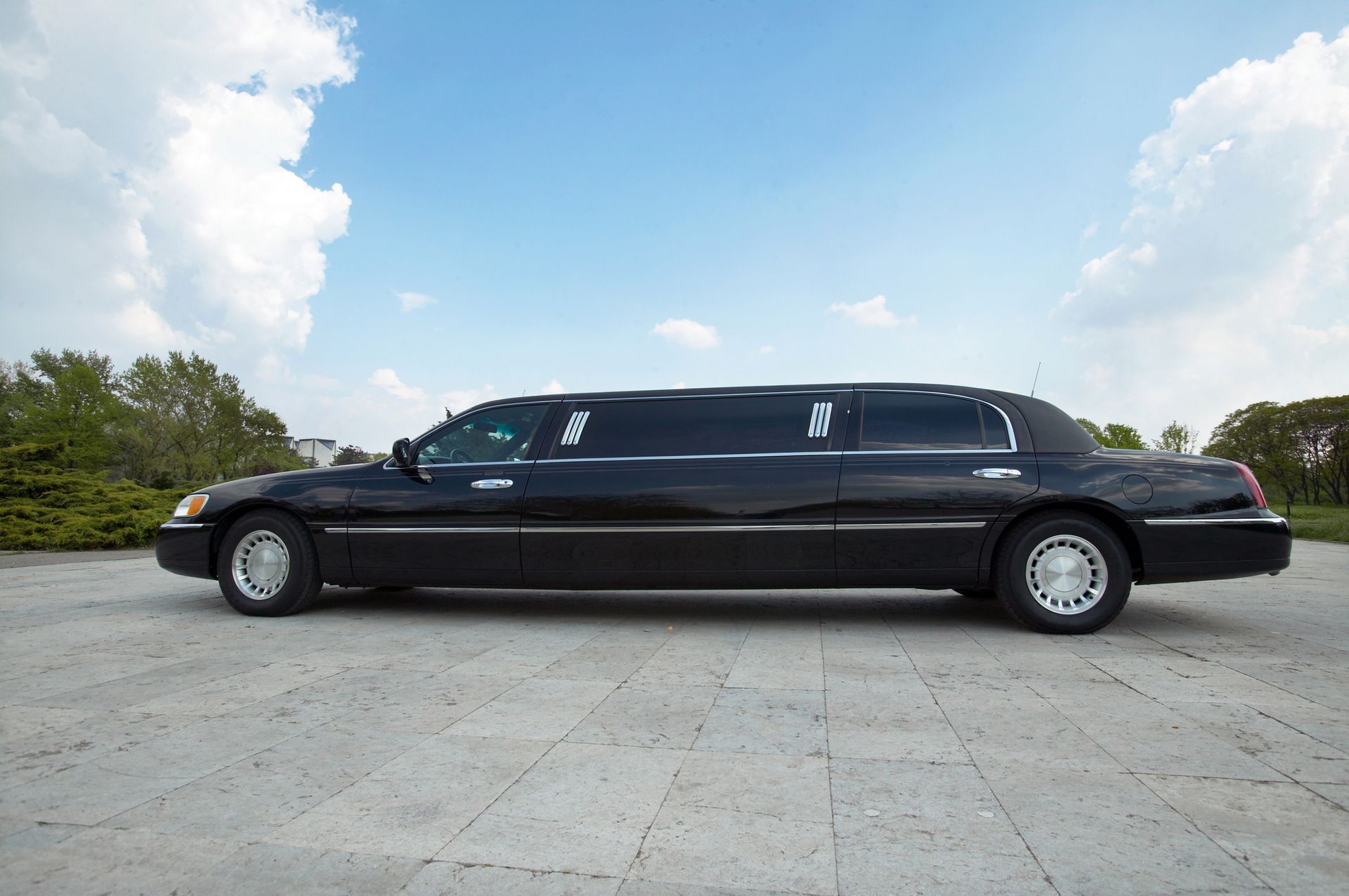 A black limousine is parked on the side of the road.