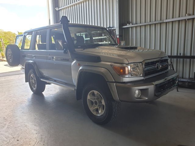 A silver toyota land cruiser is parked in a garage.