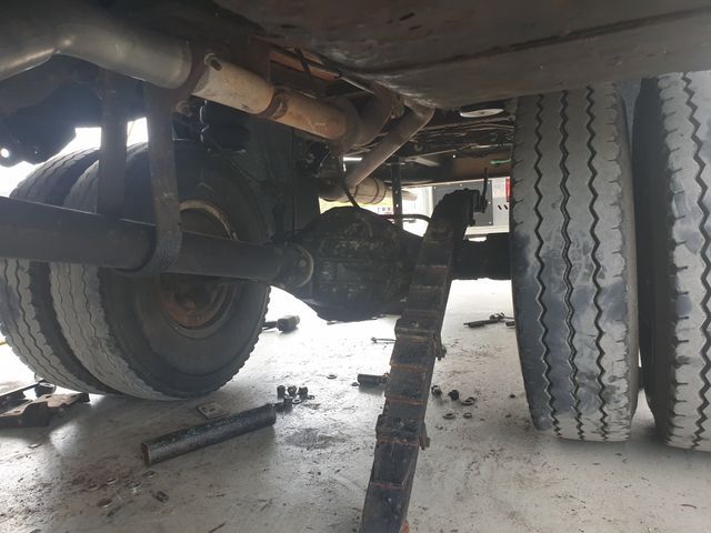 The rear end of a truck is being repaired in a garage.