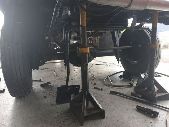 A man is working on a black suv in a garage.