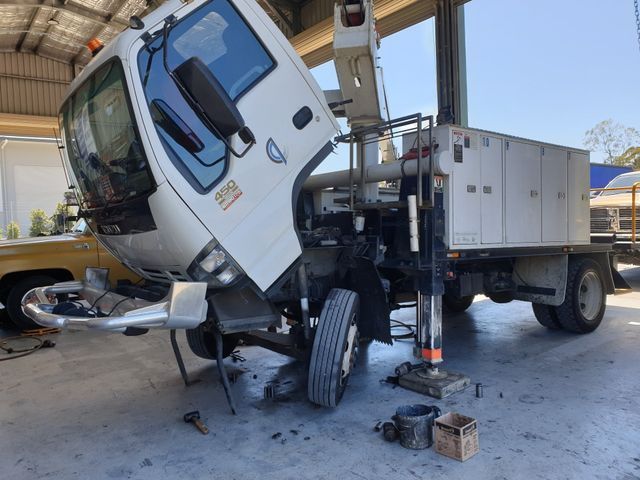 A white truck is being worked on in a garage