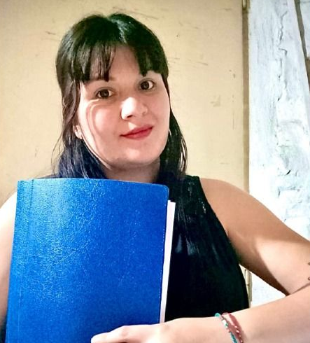 Dos mujeres están sentadas en una mesa hablando entre sí.