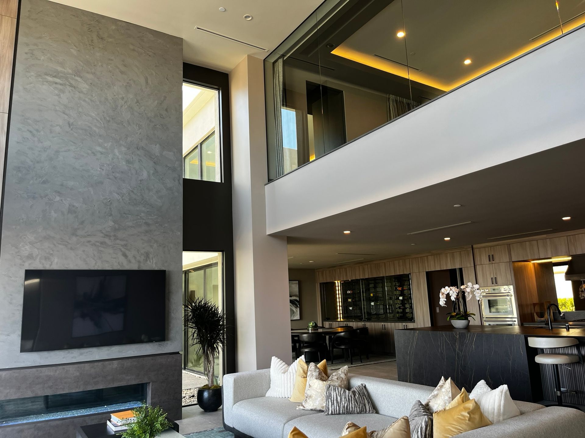 Spacious modern luxury living room with high ceilings, large windows, and elegant open-concept design.