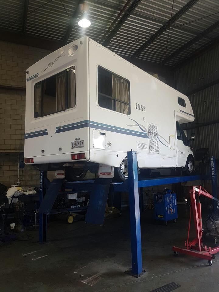 A Rv Is Sitting On Top Of A Lift In A Garage — Adrians Mechanical Services In Warana, QLD
