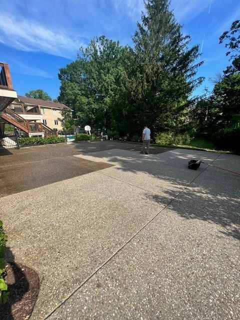 A Man Is Standing on A Concrete Driveway in Front of A House. - Bourbon City Softwash - Louisville, KY