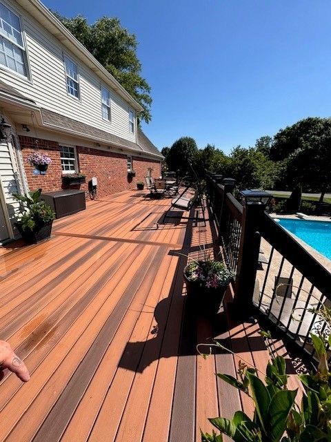 A large wooden deck with a swimming pool in the background - Bourbon City Softwash - Louisville, KY