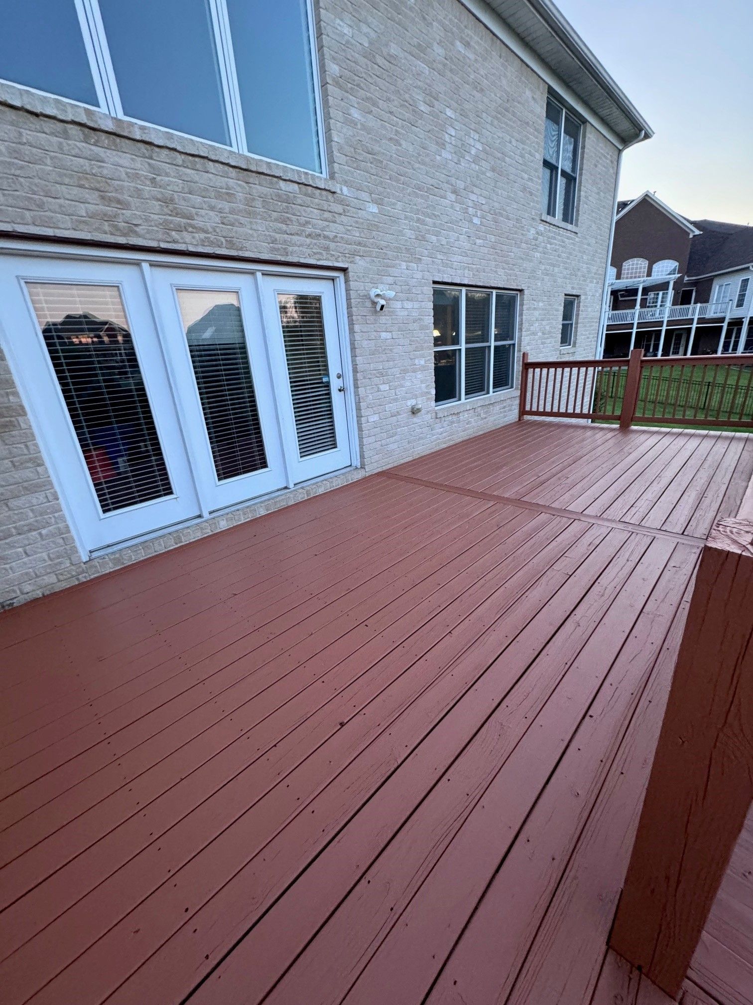 A large brick house with a large wooden deck in front of it. - Bourbon City Softwash - Louisville, KY