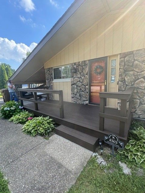 A house with a wooden porch and a stone wall. - Bourbon City Softwash - Louisville, KY