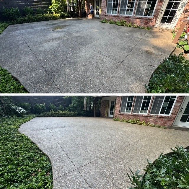 Driveway with wet paint tape, leading to a garage. Green grass and trees line the sides.