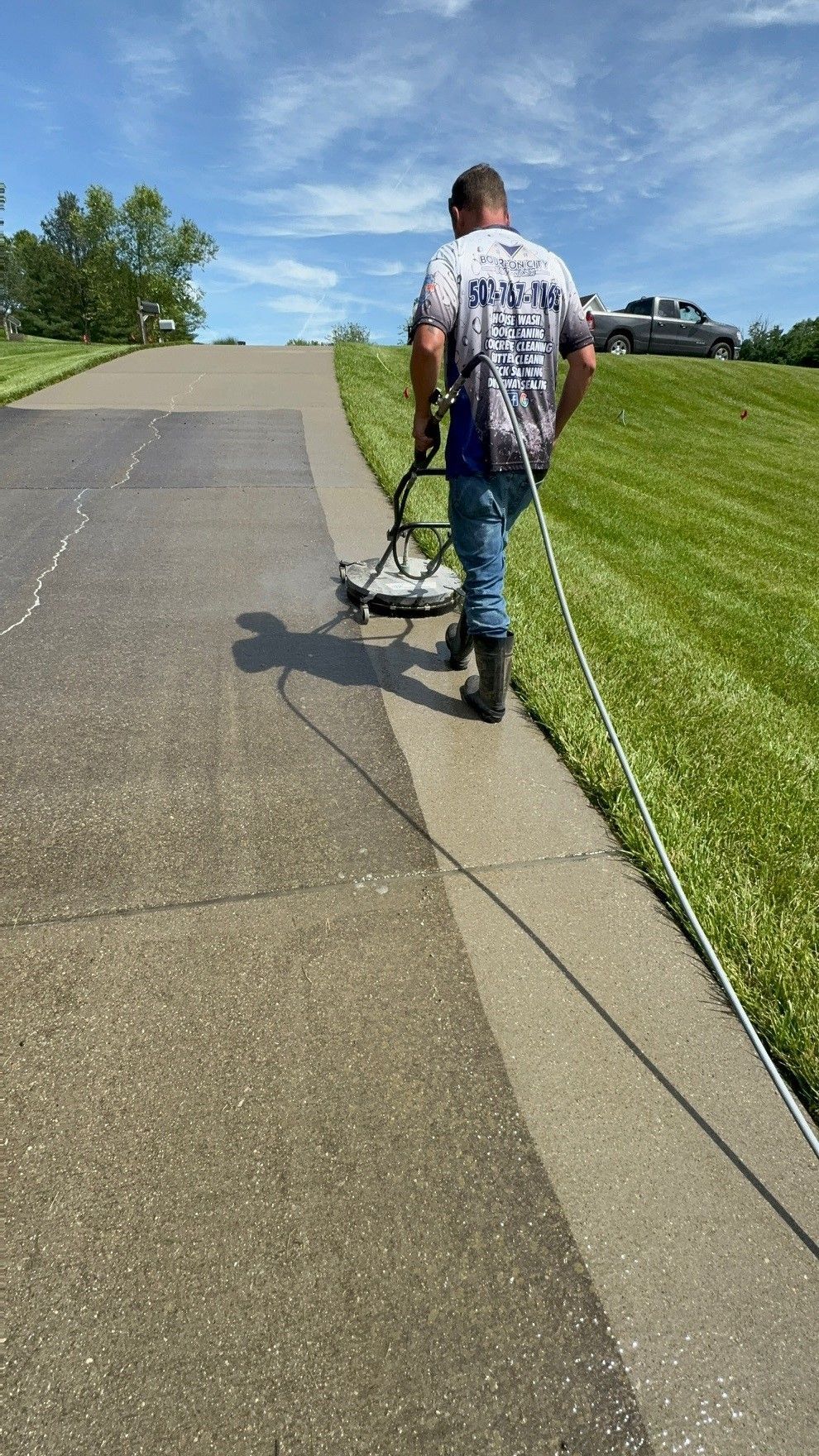 A man is cleaning a sidewalk with a machine. - Bourbon City Softwash - Louisville, KY