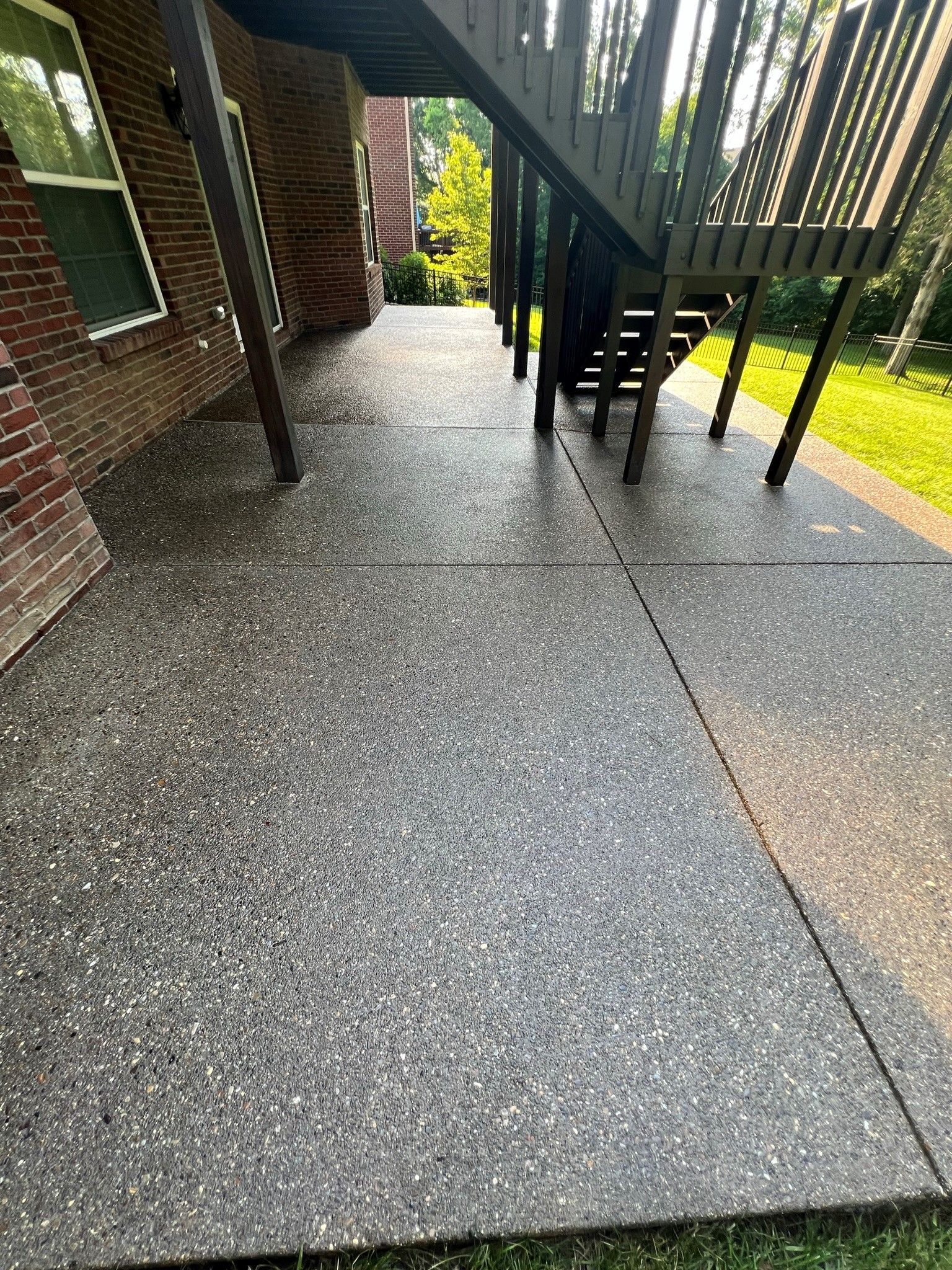 A concrete walkway with stairs leading up to a deck. - Bourbon City Softwash - Louisville, KY