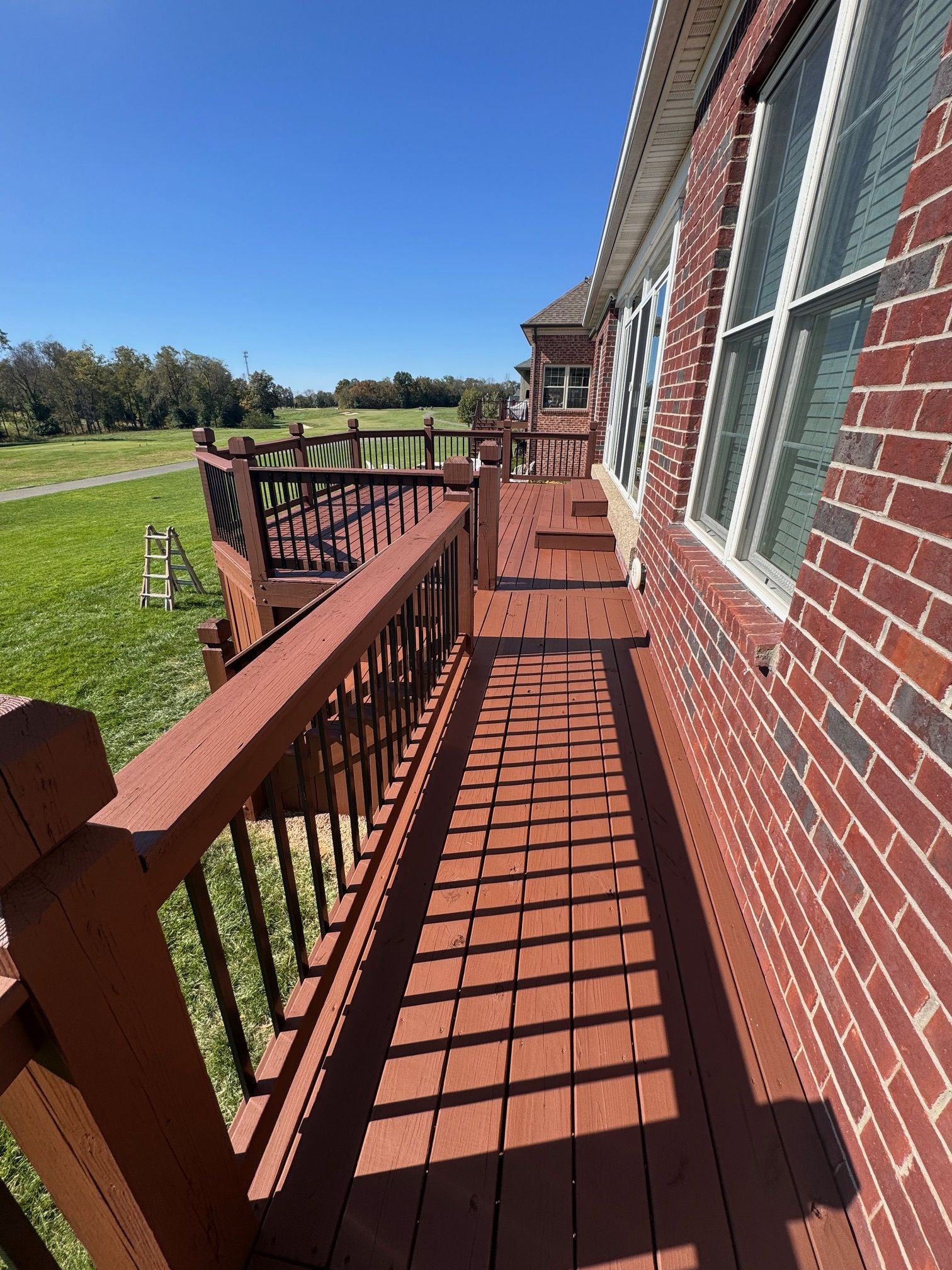 A Brick House with A Wooden Deck in Front of It.